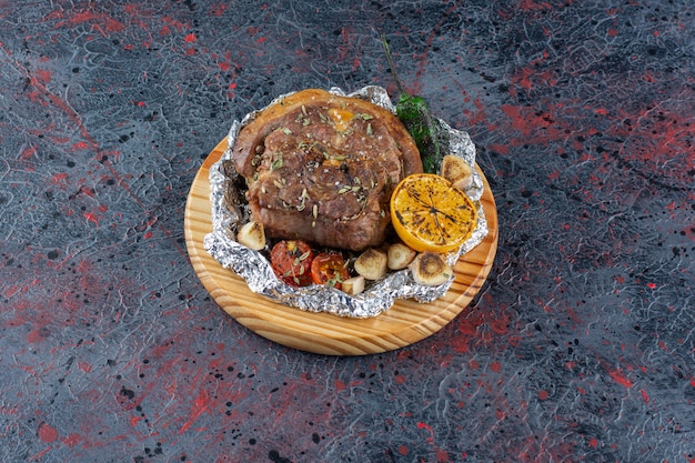 Délicieux steak juteux frais avec salade de laitue placé sur une planche à découper en bois.