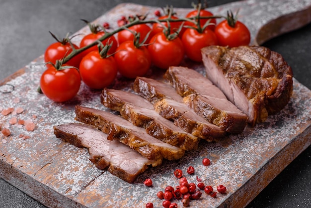 Délicieux steak de porc ou de boeuf juteux grillé avec des épices et des herbes salées sur un fond de béton texturé