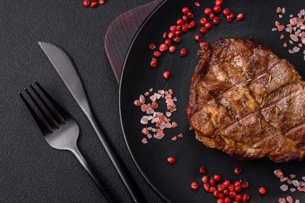 Délicieux steak de porc ou de boeuf juteux grillé avec des épices et des herbes salées