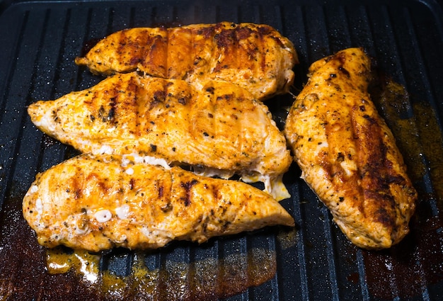 Un délicieux steak de poulet juteux assaisonné d'herbes et d'épices est frit dans un grill barbecue