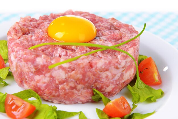 Délicieux steak tartare avec du jaune sur la plaque sur le gros plan de table