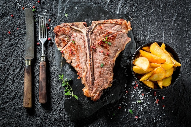 Délicieux steak tbone et frites avec sel et poivre