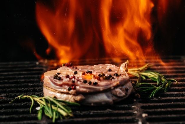 De délicieux steaks de boeuf sur le grill. steak de jarret osso buco de viande de boeuf sur le gril avec des flammes.