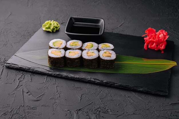 Délicieux sushi maki à l'avocat sur fond noir