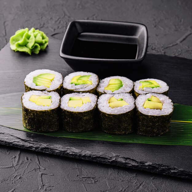 Délicieux sushi maki à l'avocat sur fond noir