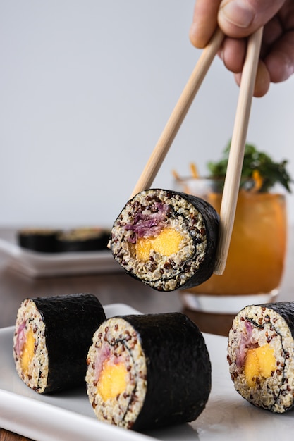 Délicieux sushi roll vegan avec des baguettes en bois