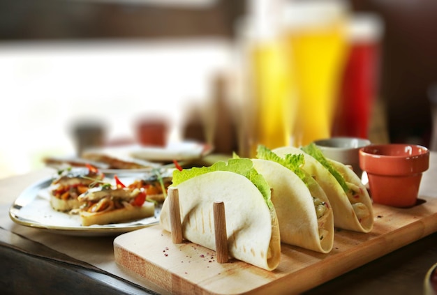Photo délicieux tacos avec filet de poisson et légumes sur plateau en bois