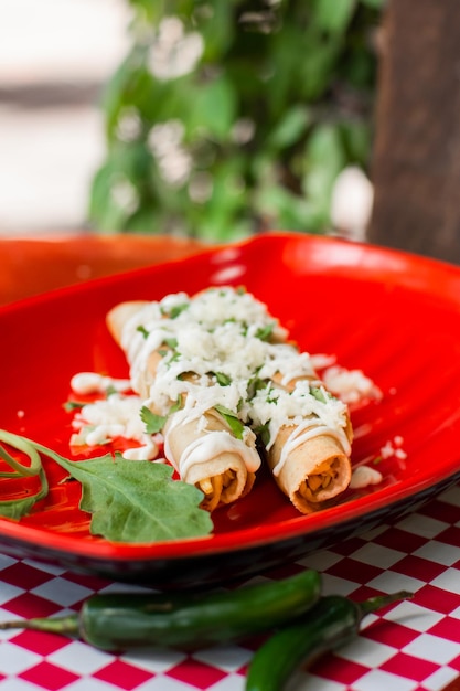 De délicieux tacos mexicains frits avec du fromage et de la crème