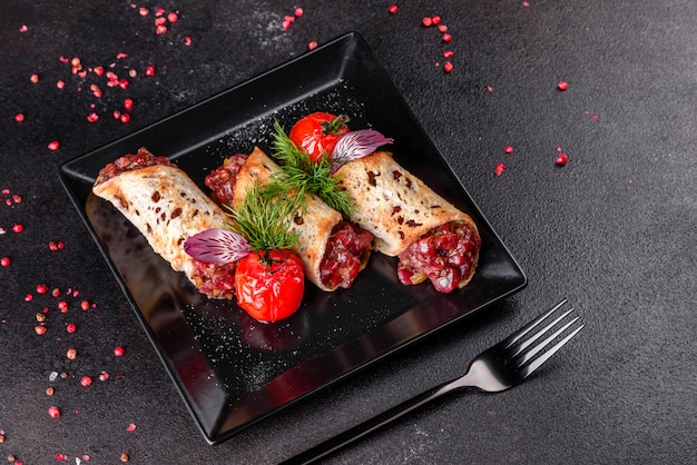 Délicieux tartare de boeuf frais avec des toasts sur une plaque carrée noire