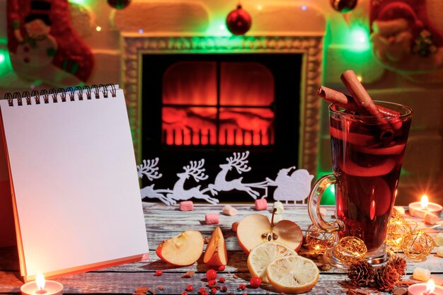 Délicieux vin chaud avec des décorations de Noël et un bloc-notes sur la table Espace de copie