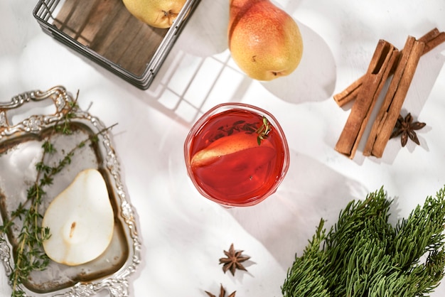 Délicieux vin rouge chaud épicé avec de la cannelle, de l'anis étoilé et de la poire en tranches servi dans une carafe et un verre pour une froide soirée d'hiver ou une boisson festive de Noël