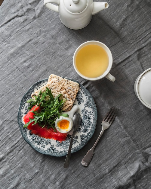 Delicious brunch petit déjeuner sain œuf bouilli légèrement salé saumon roguela pois chiches pain croustillant et thé vert sur la table vue sur le dessus