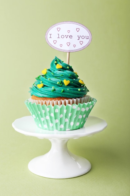 Photo delicious cupcake avec une inscription sur fond vert