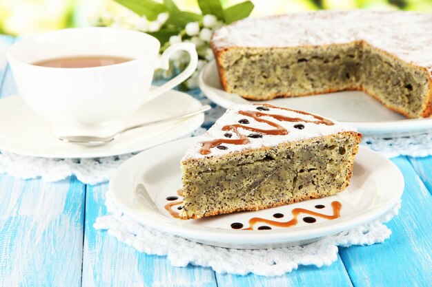 Delicious gâteau de graines de pavot avec une tasse de thé sur la table sur un fond lumineux