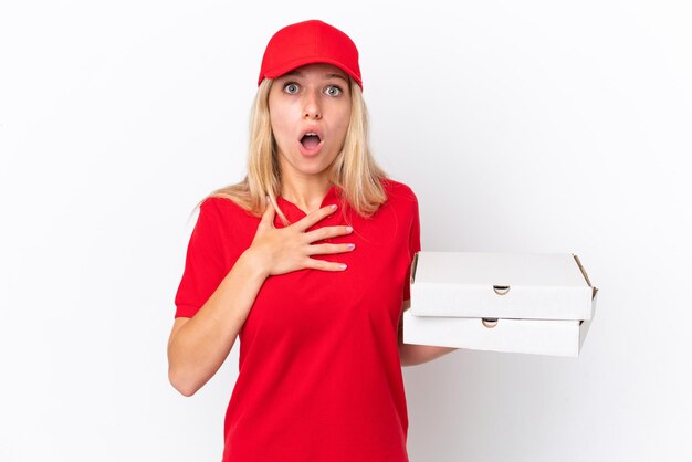 Delivery woman holding pizzas isolé sur fond blanc surpris et choqué tout en regardant à droite