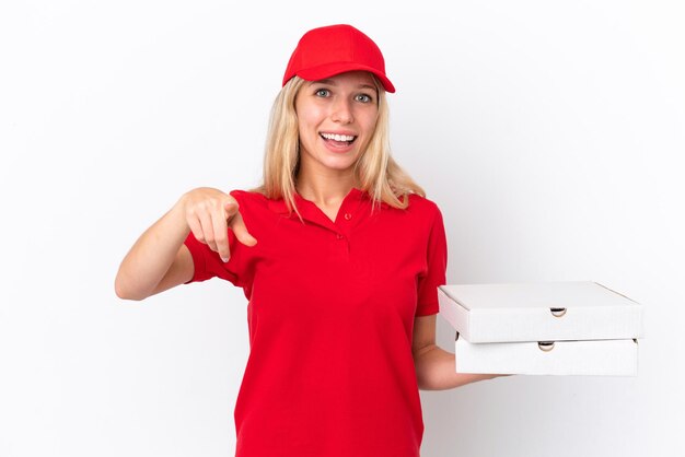 Delivery woman holding pizzas isolé sur fond blanc surpris et pointant vers l'avant