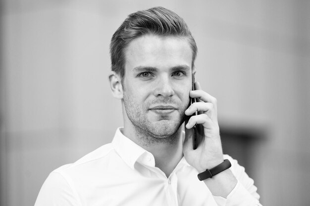 Demander des informations Homme d'affaires appelant client tenir smartphone arrière-plan urbain défocalisé Man manager conversation téléphonique Guy avec un ami d'appel smartphone Concept d'appel mobile Appel d'affaires réussi