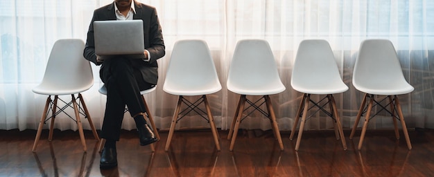 Photo demandeur d'emploi en attente d'un entretien dans la salle d'attente seul avec une chaise vide dans le couloir tout en postulant sur le formulaire de demande d'emploi concept moderne d'opportunité d'emploi et de demandeur de carrière