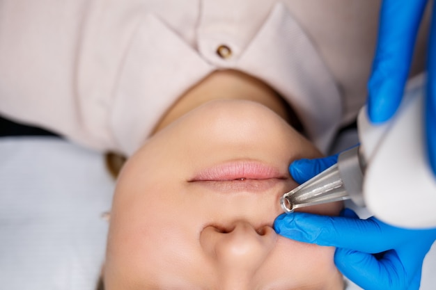 Démaquillage permanent du visage au laser. Gros plan sur une jeune femme se faisant corriger un tatouage. Correction des imperfections naturelles du visage.