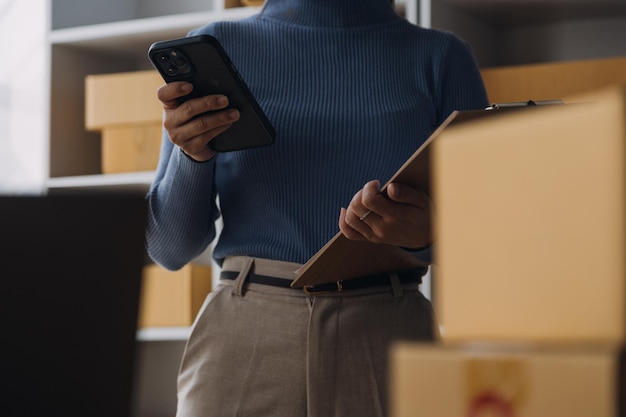 Démarrage PME petite entreprise entrepreneur de femme asiatique indépendante à l'aide d'un ordinateur portable avec boîte Succès joyeux femme asiatique sa main lève la boîte d'emballage de marketing en ligne et livraison concept d'idée PME