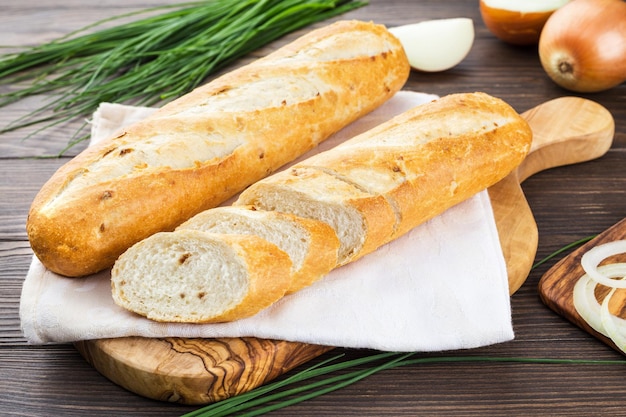 Une demi-baguette à l'oignon sur une serviette pain français fond de bois