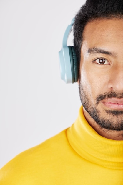 Photo demi-portrait d'homme et d'écouteurs sur fond blanc pour un podcast ou une radio en streaming visage sérieux et une personne asiatique écoutant du son ou une piste isolée sur fond de studio