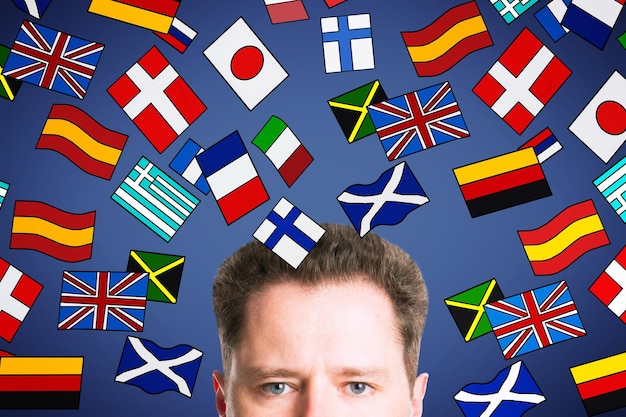 Demi-portrait d'un jeune homme d'affaires européen séduisant avec des dessins abstraits de drapeaux colorés Traduction de voyage et concept d'apprentissage des langues