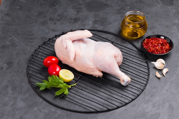 Demi-poulet cru avec peau disposé sur grill