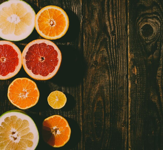 Demi-tranches fraîches oranges pamplemousse mandarine citron sur une table bleue en bois