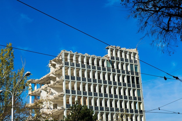 Démolition de l'ancien bâtiment avec sloopkraan contre ciel bleu nuages