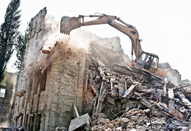 Démolition à l'excavatrice d'un bâtiment ancien