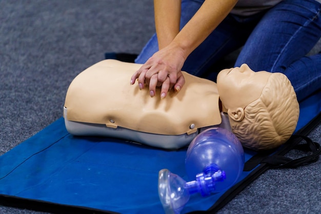 Démonstration de compressions thoraciques. La poupée médicale est le simulateur de formation aux premiers secours. Formation en massage cardiaque. Concept d'éducation et de pratique médicales.