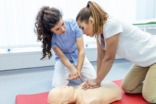 Démonstration de la procédure médicale de formation en réanimation cardiopulmonaire sur la poupée de RCP dans la classeLes étudiants en médecine et en infirmière apprennent à sauver le patientPremiers secours pour le concept de vie sûre