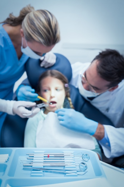 Dentiste avec assistant examinant les dents des filles