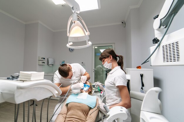 Le dentiste et l'assistant examinent les dents du patient. Équipement médical moderne. Concept de traitement oral. Fermer. Mise au point sélective.