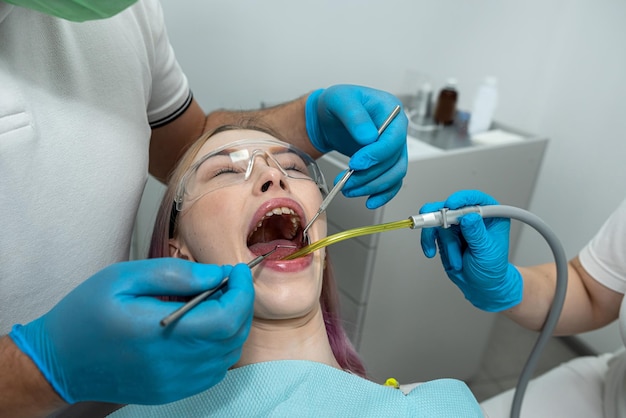 un dentiste et une assistante traitent un patient