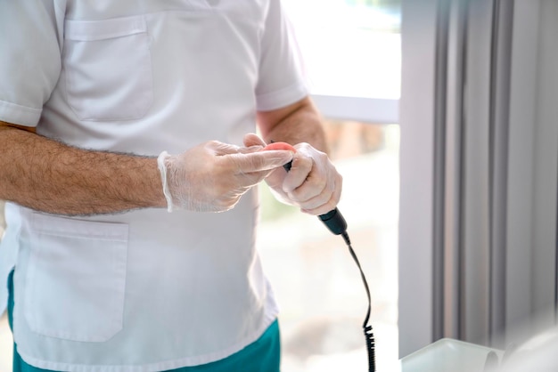 Le dentiste corrige la prothèse amovible avec un outil spécial