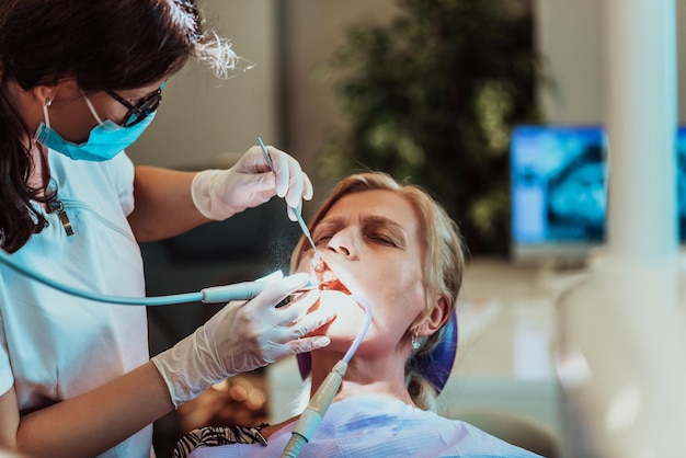Un dentiste dans un cabinet dentaire moderne effectue une chirurgie de la mâchoire sur un patient âgé. Photo de haute qualité