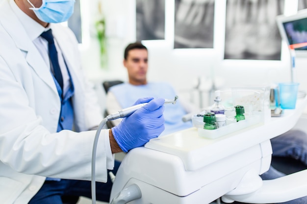 Dentiste dans son bureau prêt à examiner les dents de son patient.