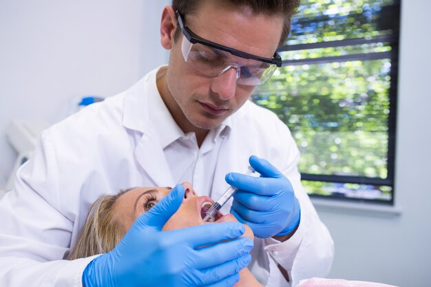 Dentiste donnant une anesthésie à la femme à la clinique médicale