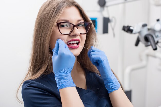 Dentiste avec du fil dentaire