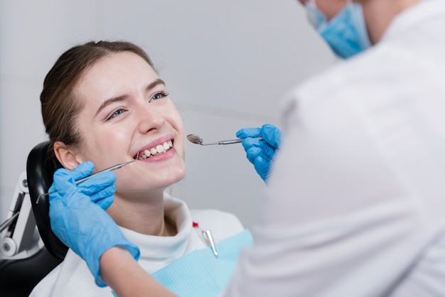 Photo dentiste effectuant un contrôle dentaire sur le patient