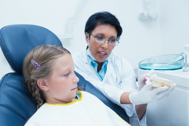 Dentiste enseigne à la fille comment se brosser les dents