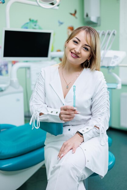 Le dentiste est dans son cabinet dentaire Femme dentiste en blouse blanche Cabinet dentaire