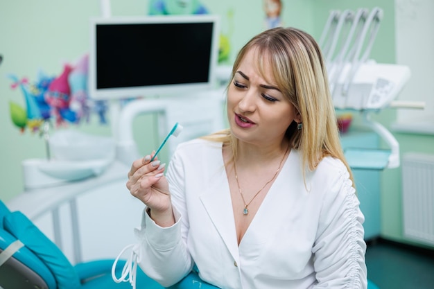 Le dentiste est dans son cabinet dentaire Femme dentiste en blouse blanche Cabinet dentaire