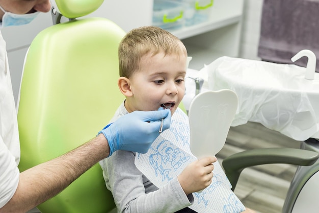 Dentiste examinant les dents du petit garçon à la clinique Problème dentaire