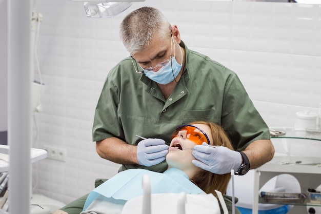 Dentiste examinant les dents de la jeune fille à la clinique Problème dentaire