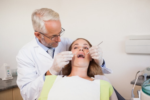 Dentiste examinant les dents d&#39;un patient dans la chaise des dentistes