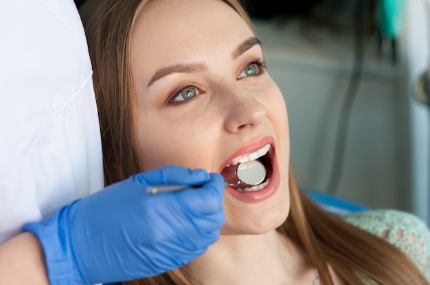 Dentiste examinant les dents d'un patient dans la clinique dentaire.