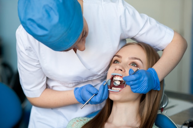 Dentiste examinant les dents d'un patient dans la clinique dentaire.